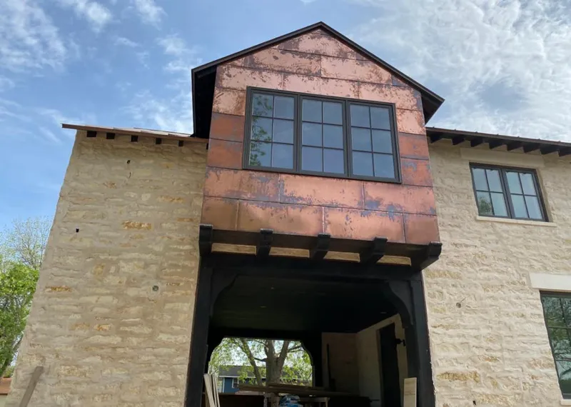Copper metal panel facade on a stone building for Skylight Installation in Wright