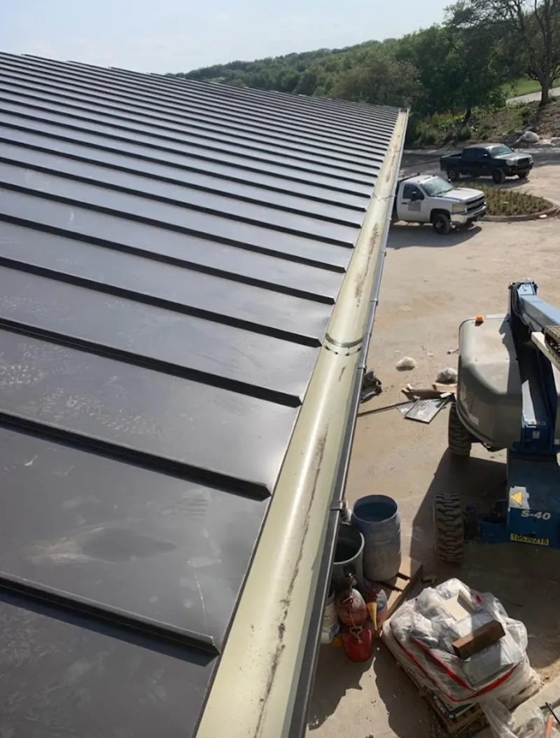 Standing seam panel and gutter detail on a metal roofing jobsite in Wright